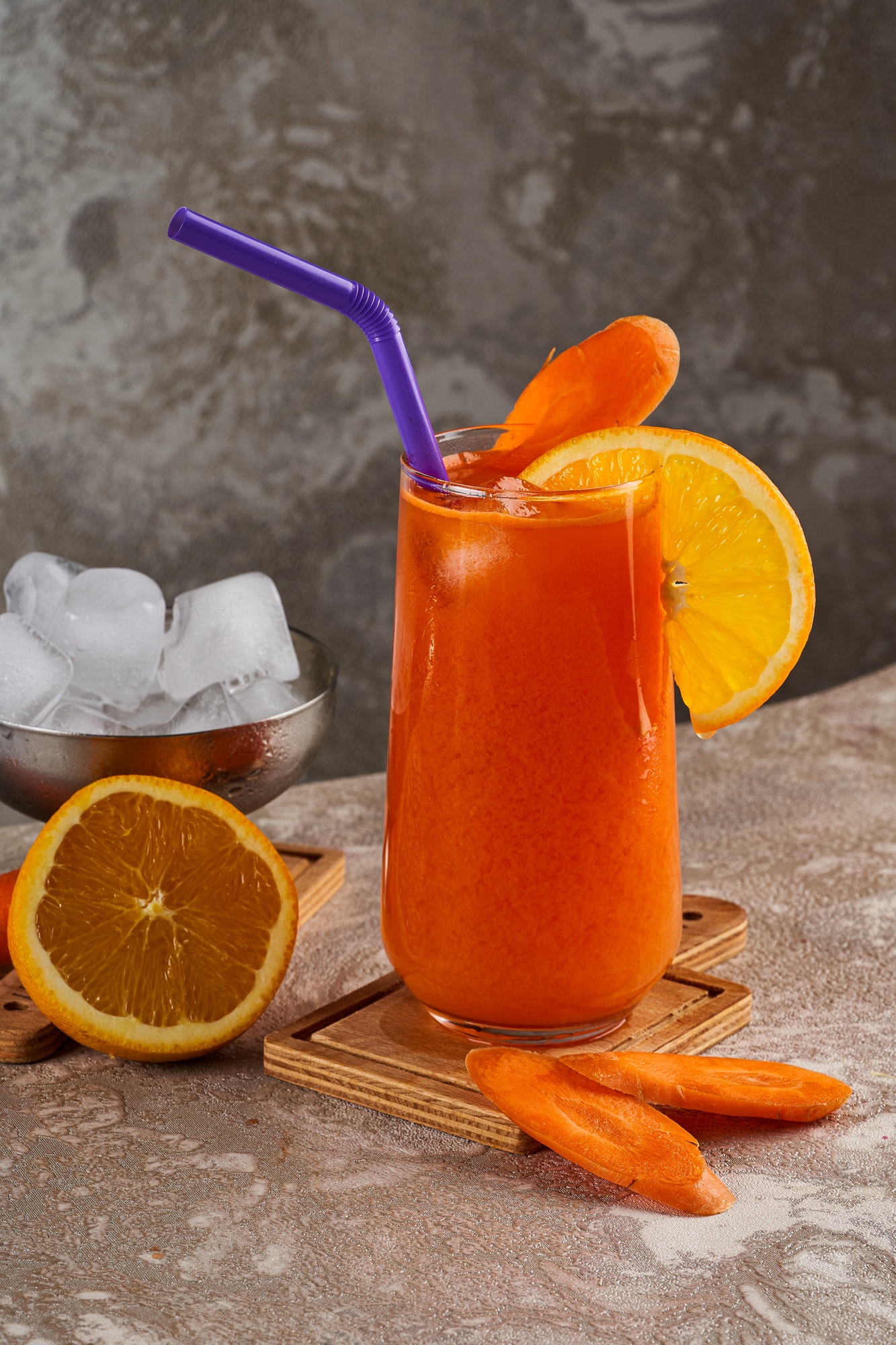 A cup of orange and carrot juice on a wooden floor