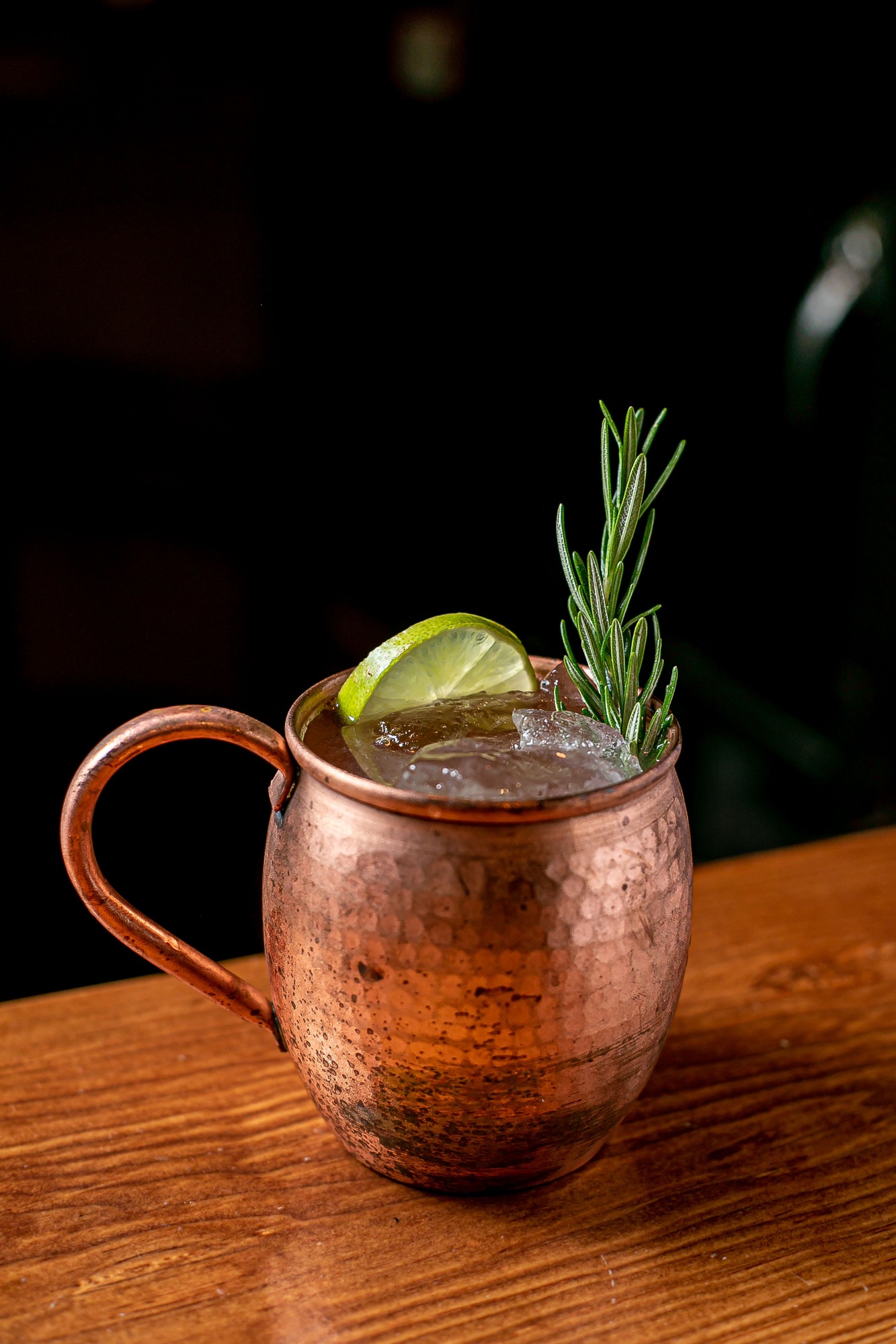 Closeup of a copper mug of Moscow mule cocktail on a bar counter