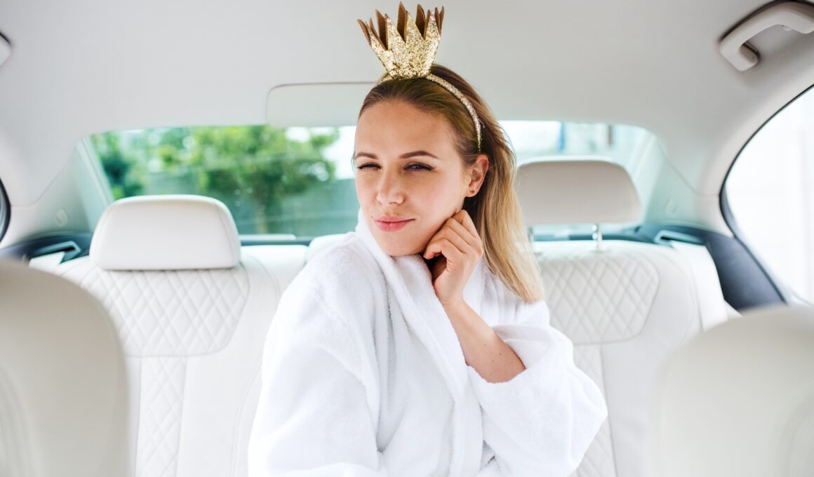 Young woman with party accessories sitting in car, having fun