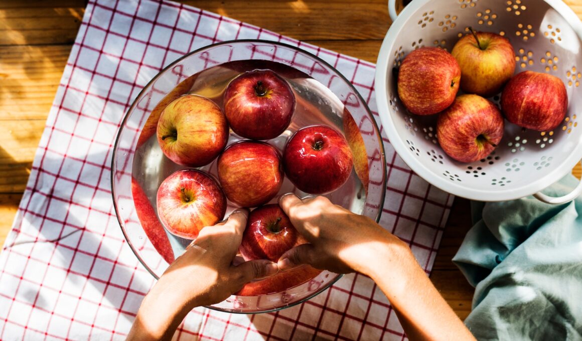 Aerial view of hands washing apples in bowl